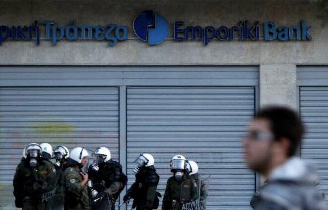 La police anti-émeute protège une banque athénienne lors d'un rassemblement contre les mesures d'austérité. © Yiorgos Karahalis/Reuters La police anti-émeute protège une banque athénienne lors d'un rassemblement contre les mesures d'austérité. © Yiorgos Karahalis/Reuters